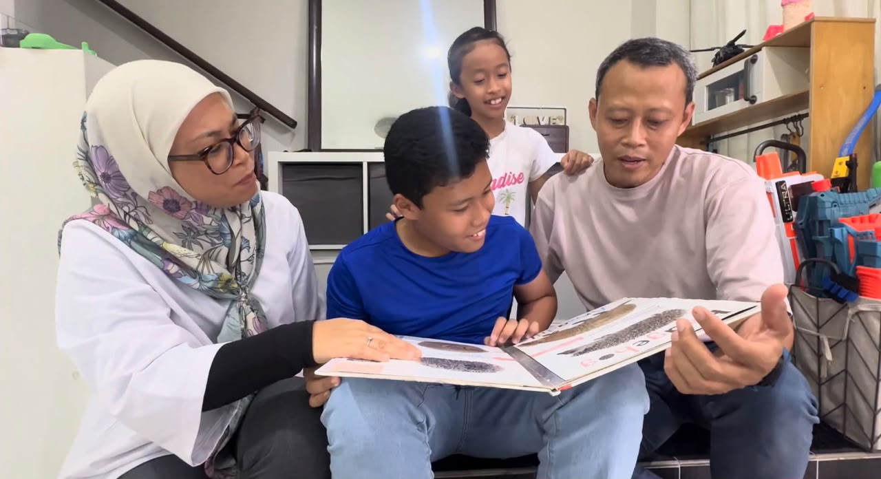 Bapa dan ibu membelek album bersama anak-anak