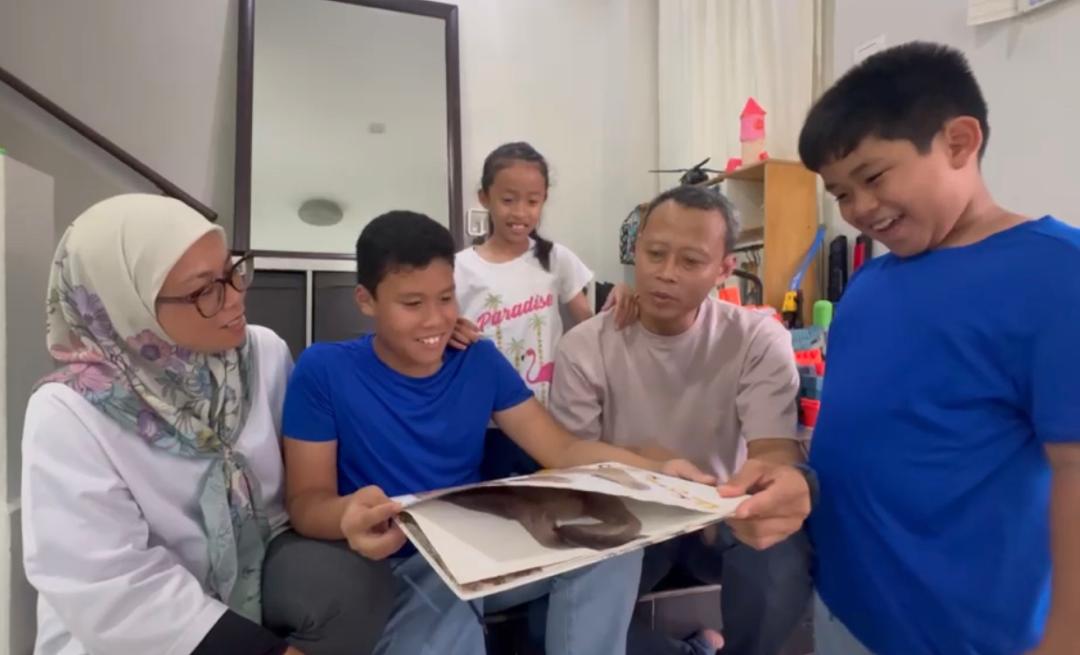 Sebuah keluarga membaca buku bersama di rumah